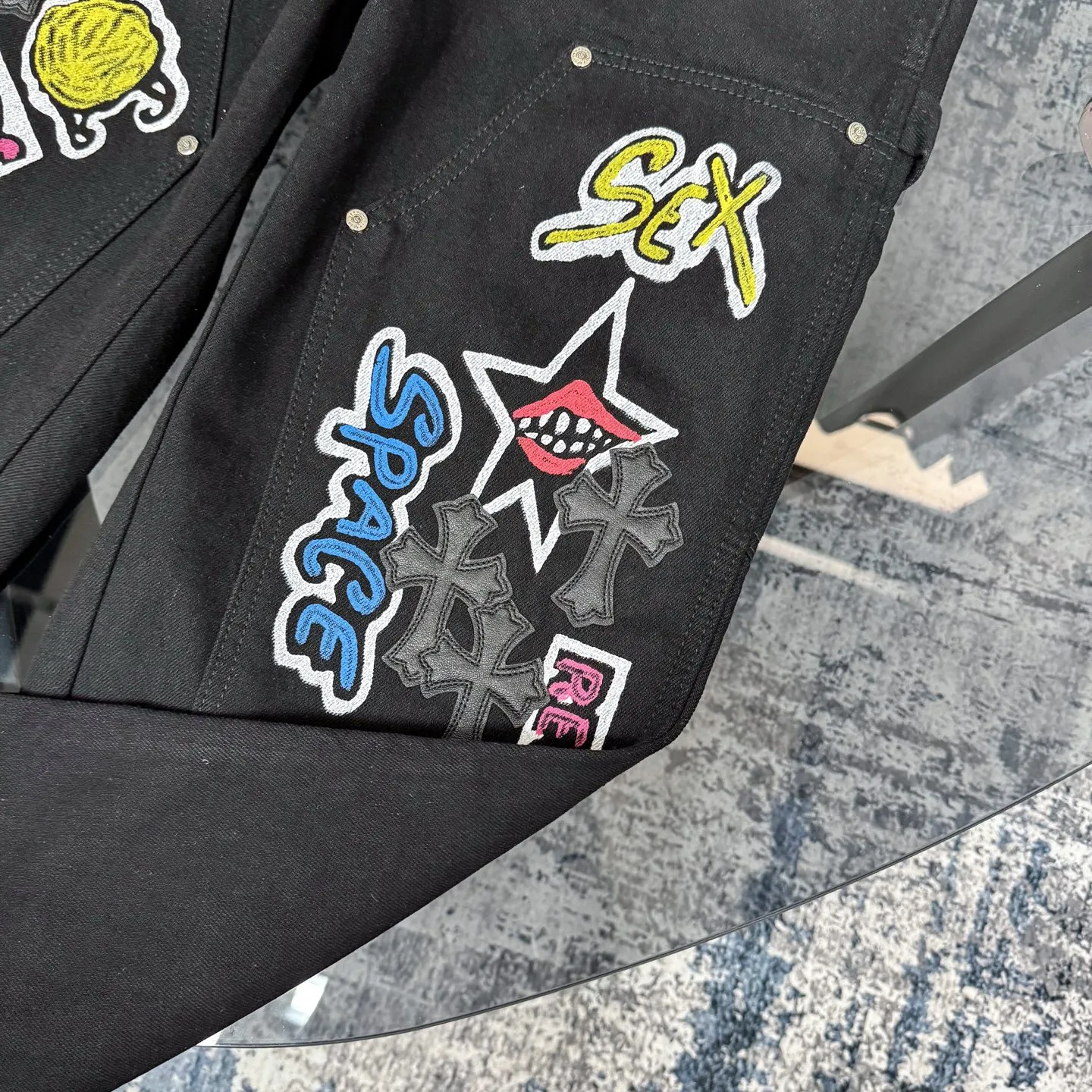 P260 Chrome Hearts Chrome Hearts black multi-element graffiti overalls Chrome Hearts clothing creative director Mattyboy Mattyboy, whose real name is Matt DiGiacomo, is a graffiti artist with a non-school background. He started to serve as the creative director of the Chrome Hearts clothing series in 2018. Since then, Chrome Hearts, which has been injected with young blood, has become popular again. Popular clothing and leather goods, especially the vintage trousers modified product line, must be pre-ordered in stores around the world. Especially patterns like Checker Ball, Checker Eyes and Smiling Lips. The fictional record company logo "SexRecords" often appears in his works, forming his unique style. "I hate humanity, but I love art. Before the end of my life, I just want to do my best to create." ----Matty Boy Mattyboy and vrigil Abloh are also very close. They are both ICONs who bring street culture into luxury accessories. Via.MattyBoy90 (IG) Size: 28/30/32/34/36 Waist: 69/74/79/84/89 Knee circumference: 50/51.5/53/54.5/56 Pants length: 102/104/106/108/110